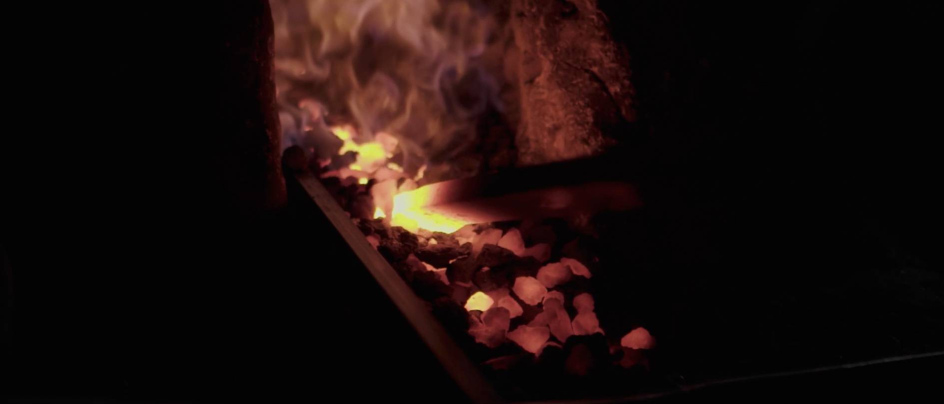 画像: この画像は、鍛冶場で加熱される炎と炭を示しています。赤熱した炭が明るく光り、炎が強く燃えています。関連キーワード: 鍛