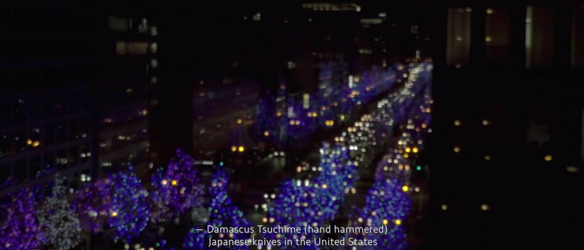 画像: 申し訳ありませんが、この画像に関する具体的な説明はできません。画像には夜の都会の風景が含まれており、青や紫のイルミネーションが並木道を彩っています。関連キ